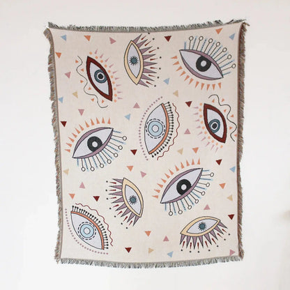 Decorative throw blanket with eye pattern on a white background