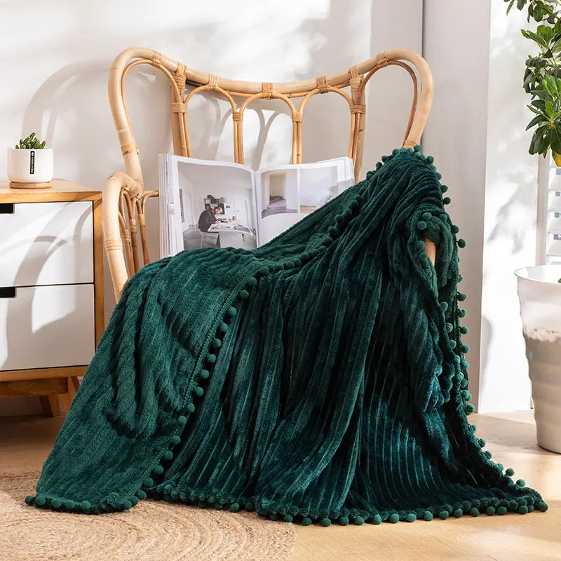 Pom pom blanket with striped velvet flannel design adding charming decor accent