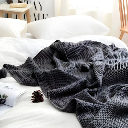 Soft knit blanket with tassel edge designed for lounging and home comfort