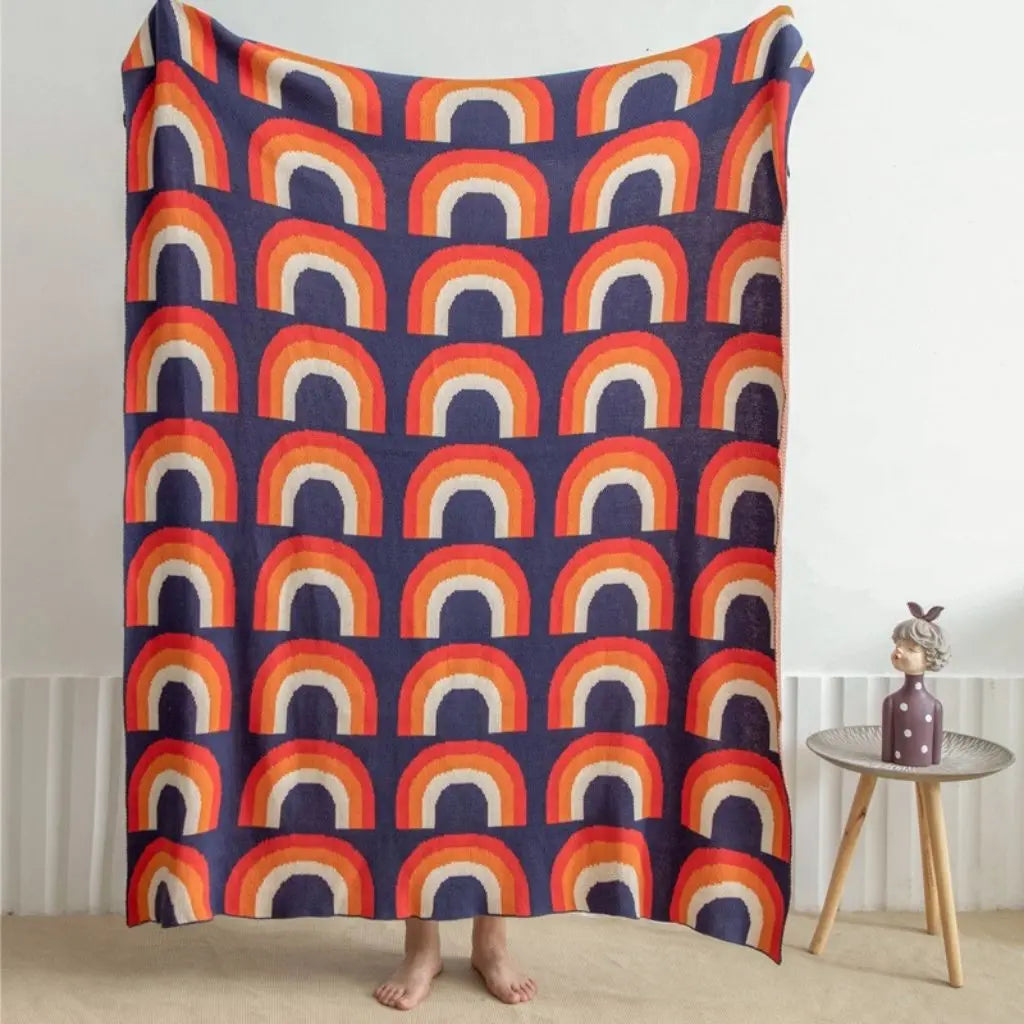 Soft cotton knit rainbow blanket with multicolor design ideal for layering and decor