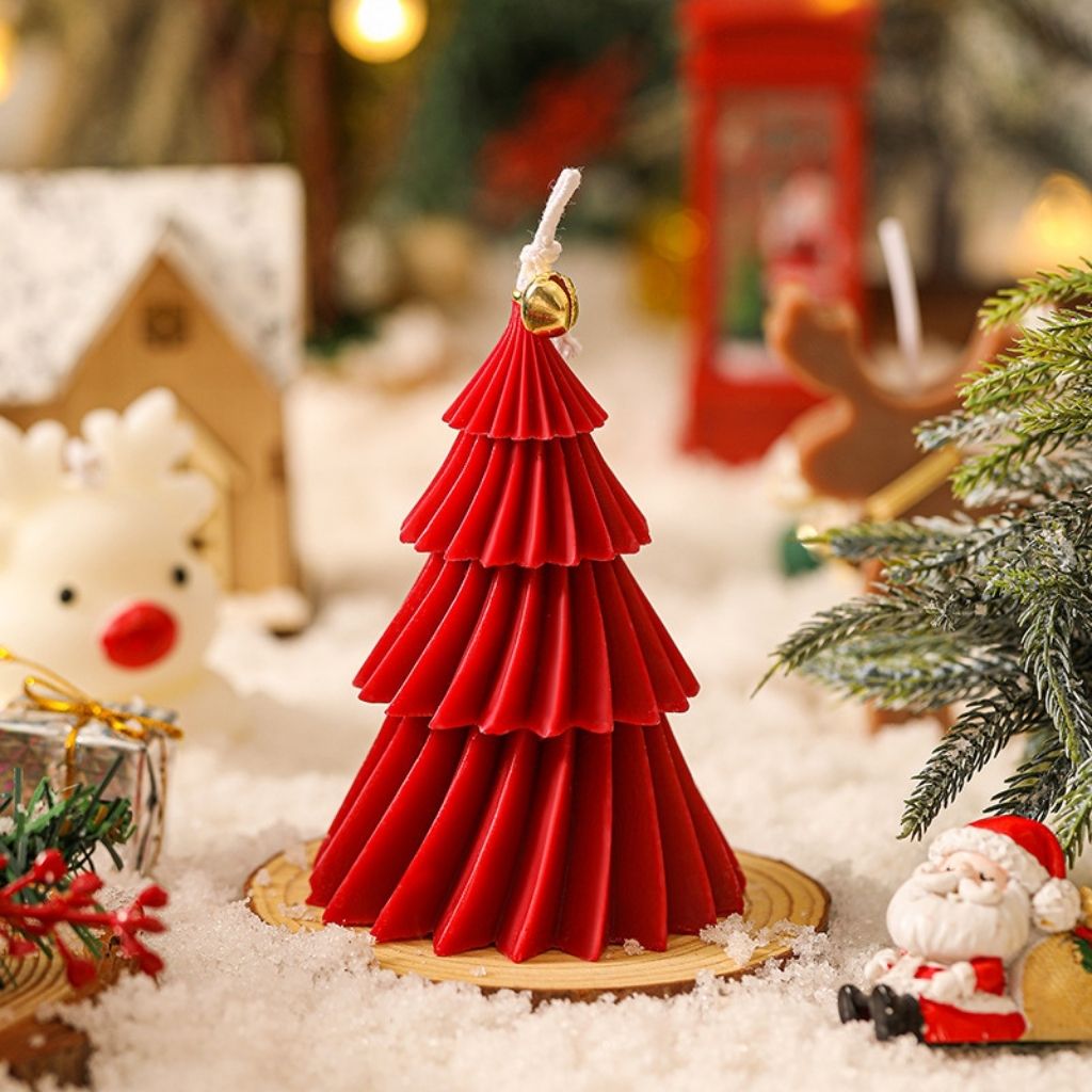 Tiered spiral candle in Christmas tree shape with hanging bell detail for holiday decor