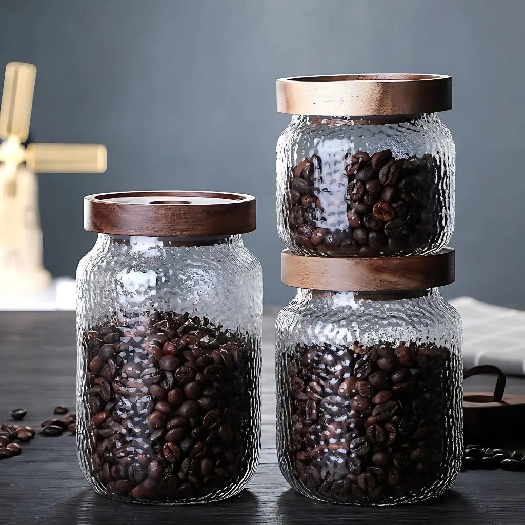 Glass vessel with tight-sealing wooden lid designed for fresh ingredient storage in contemporary kitchens.