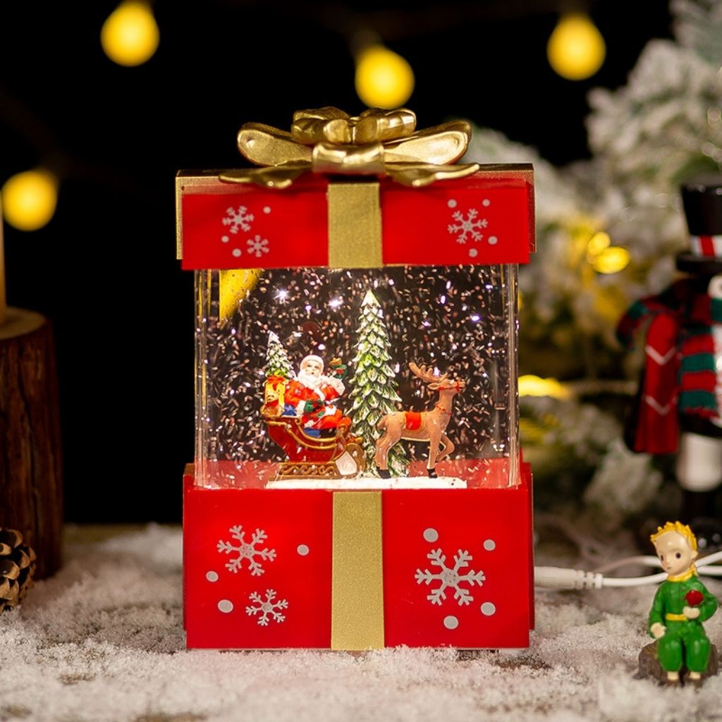 Glowing Christmas decoration featuring present shape with snow globe window