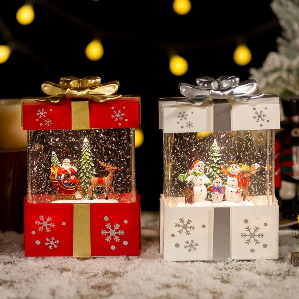 LED holiday lamp shaped like wrapped present with miniature winter village