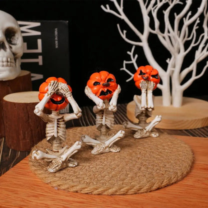 Halloween-themed decorations with skeleton hands and pumpkin faces on a wooden surface.