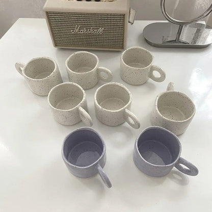Speckled ceramic coffee mug filled with coffee showcasing practical daily use and artistic design.