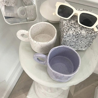Collection view of speckled ceramic coffee mugs displaying unique glaze patterns and craftsmanship.