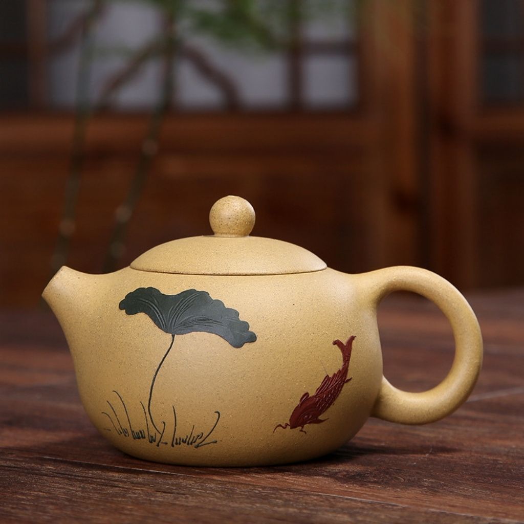 Close up of curved spout and hand painted calligraphy on purple clay teapot body