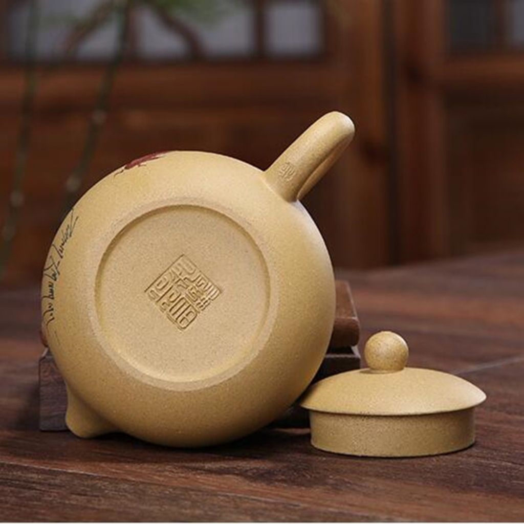 Purple clay teapot pouring tea into small cup demonstrating smooth spout flow